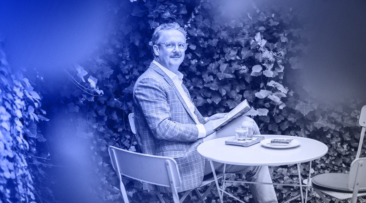 Vladan Hejnic sedí u stolu na zahradě, čte knihu a užívá si volný pátek.