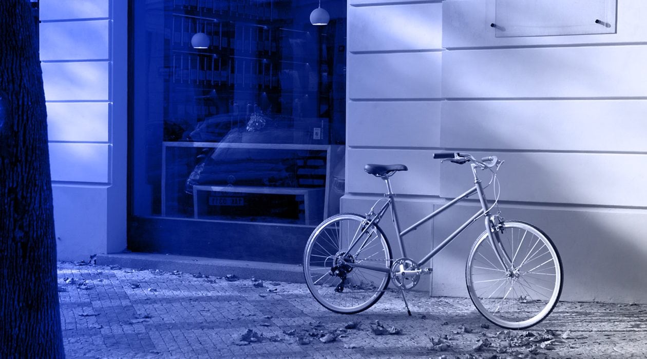 Vladan Hejnic s lehkým kolem před moderní budovou v centru města.