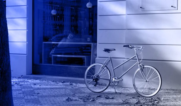 Vladan Hejnic s lehkým kolem před moderní budovou v centru města.