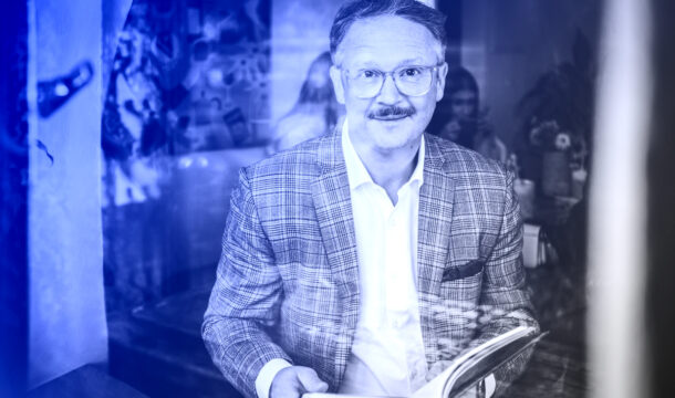 Vladan Hejnic s úsměvem drží knihu, symbol naděje a motivace.