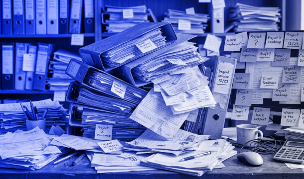 Chaos s dokumenty na stole, Vladan Hejnic v pozadí.